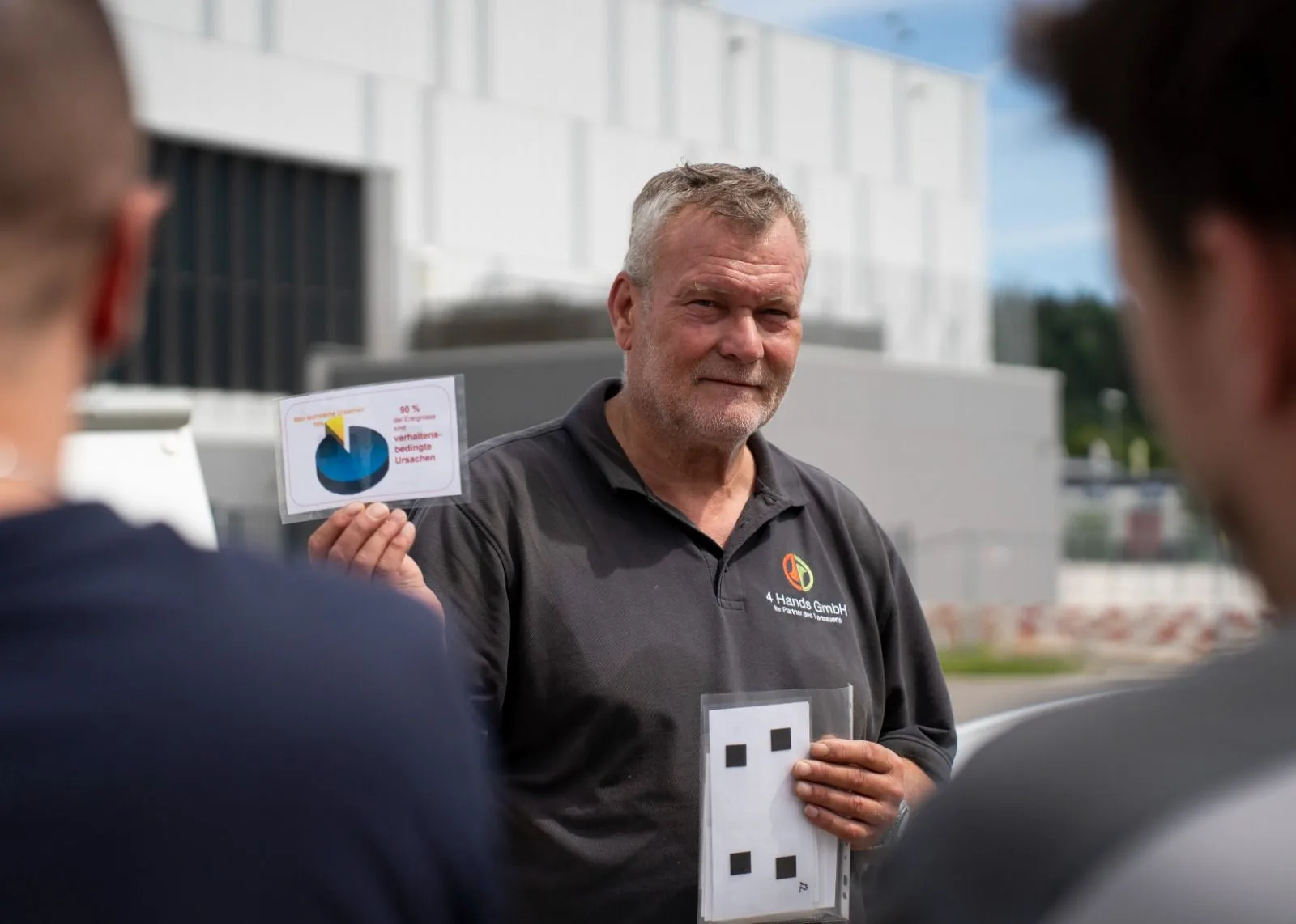 Kursleiter der 4 Hands GmbH erklärt Teilnehmenden die Ursachen von Bränden