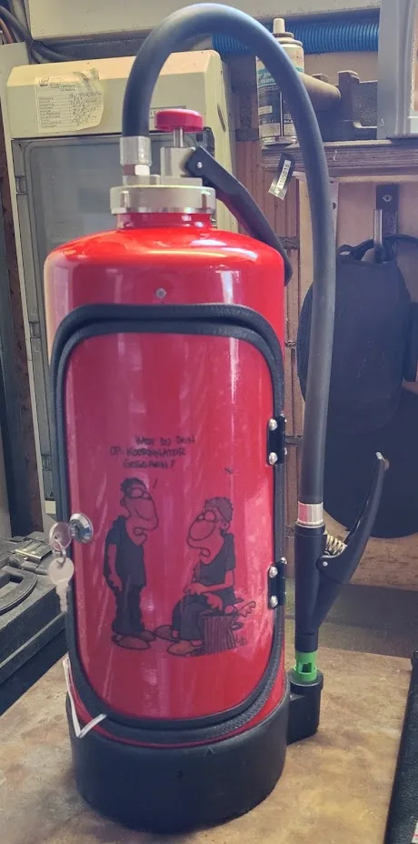Roter Feuerlöscher mit handgemaltem Cartoon-Motiv auf der Türe